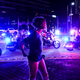 A woman looks at the Police convoy as Democratic presidential nominee and former Vice President Joe Biden arrives for an NBC townhall outside of the Perez Art Museum in Miami, Florida on October 5, 2020.